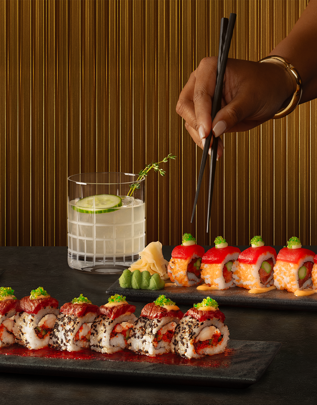 Eddie V's chef-crafted sushi with a cocktail next to text that reads: 'Roll with Eddie. April 6th to May 31st in the V Lounge. 
                Pair a chef-crafted sushi roll with a dazzling cocktail or glass of wine. View Menu.