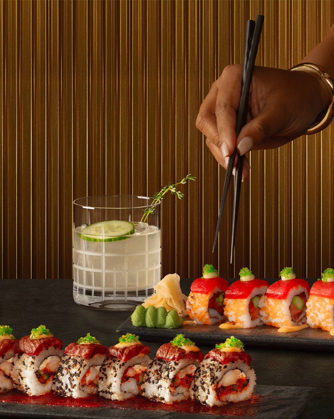 Eddie V's chef-crafted sushi with a cocktail next to text that reads: 'Roll with Eddie. April 6th to May 31st in the V Lounge. 
                Pair a chef-crafted sushi roll with a dazzling cocktail or glass of wine. View Menu.